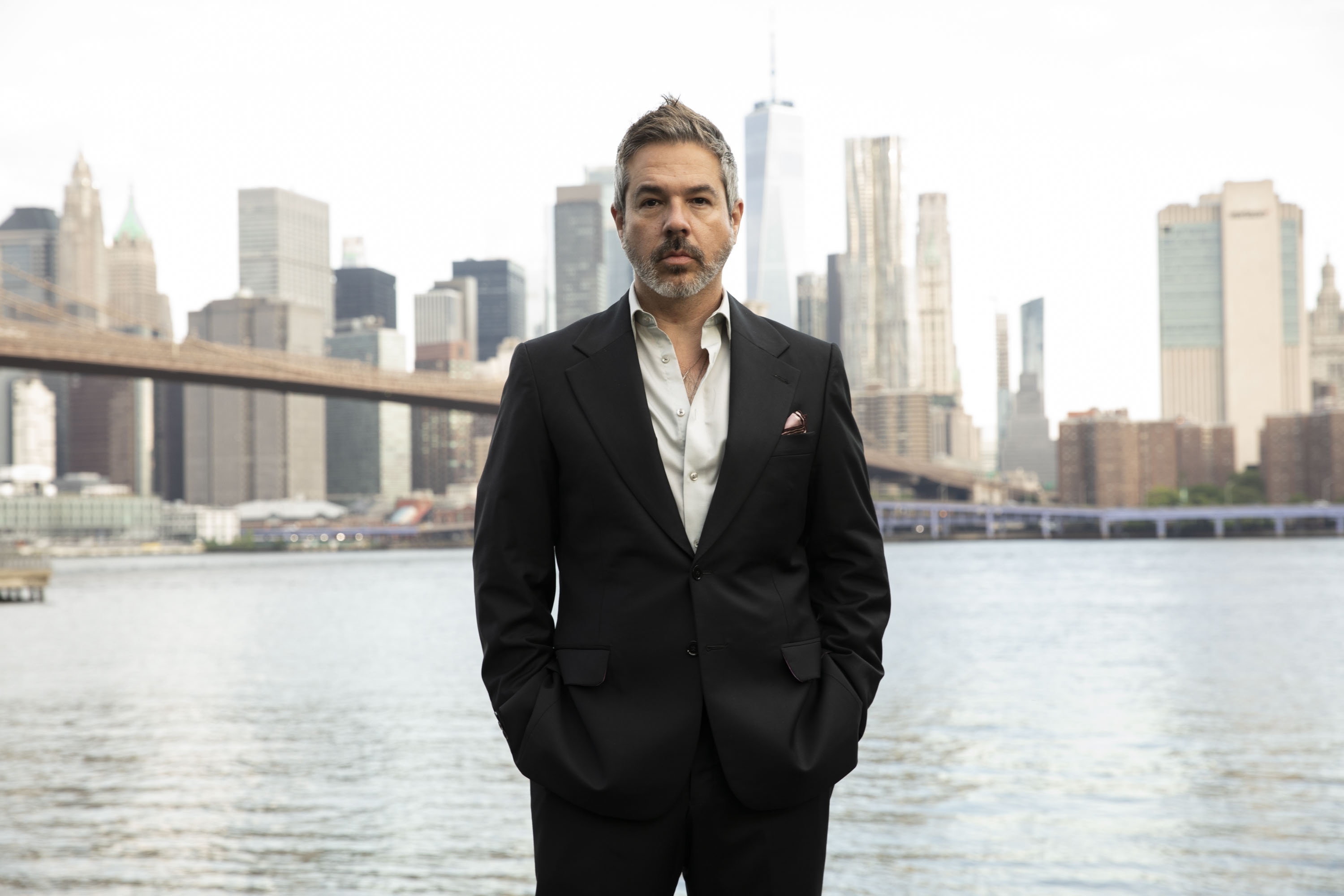 Daniel Tuttle against the Brooklyn skyline — the invitation video arrives here